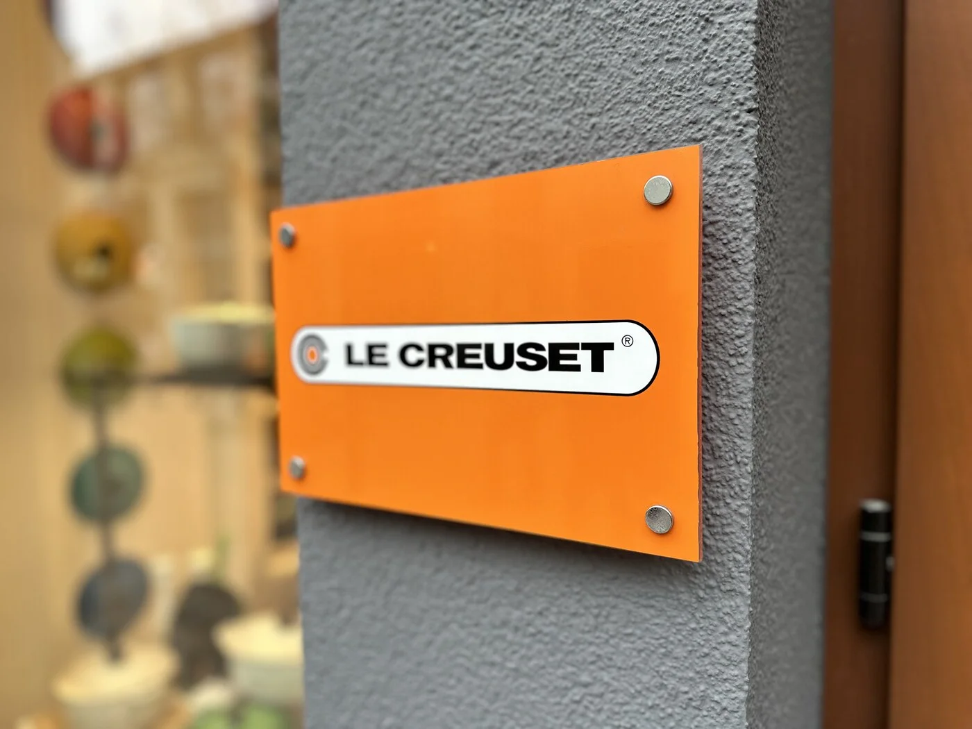 Le Creuset store orange acrylic sign mounted with four silver standoffs
