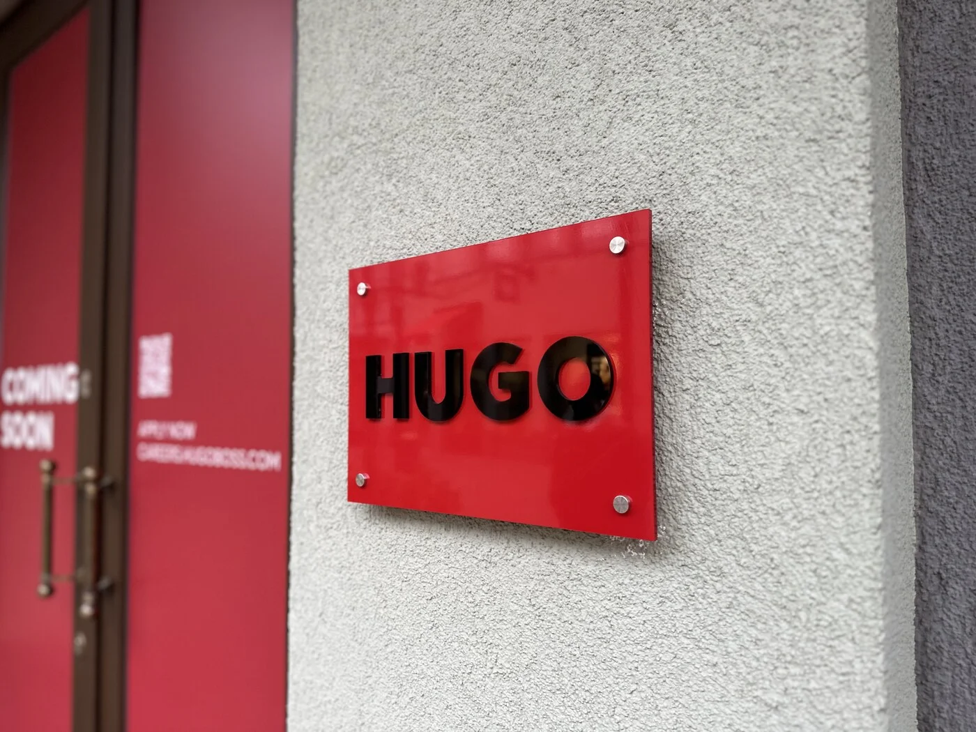 Retail store sign mounted on silver standoffs