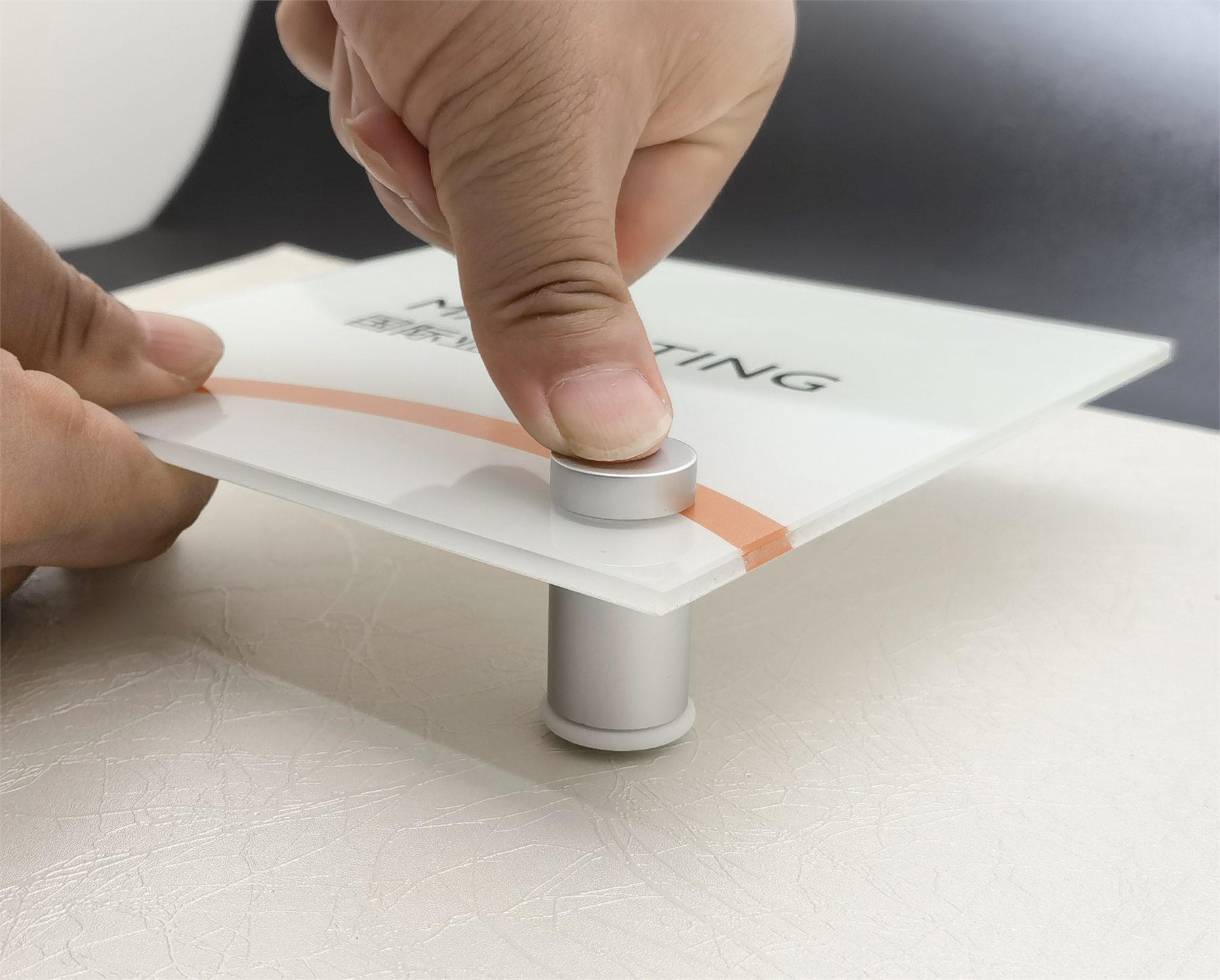 Plastic locator being used to align a sign standoff during acrylic panel installation