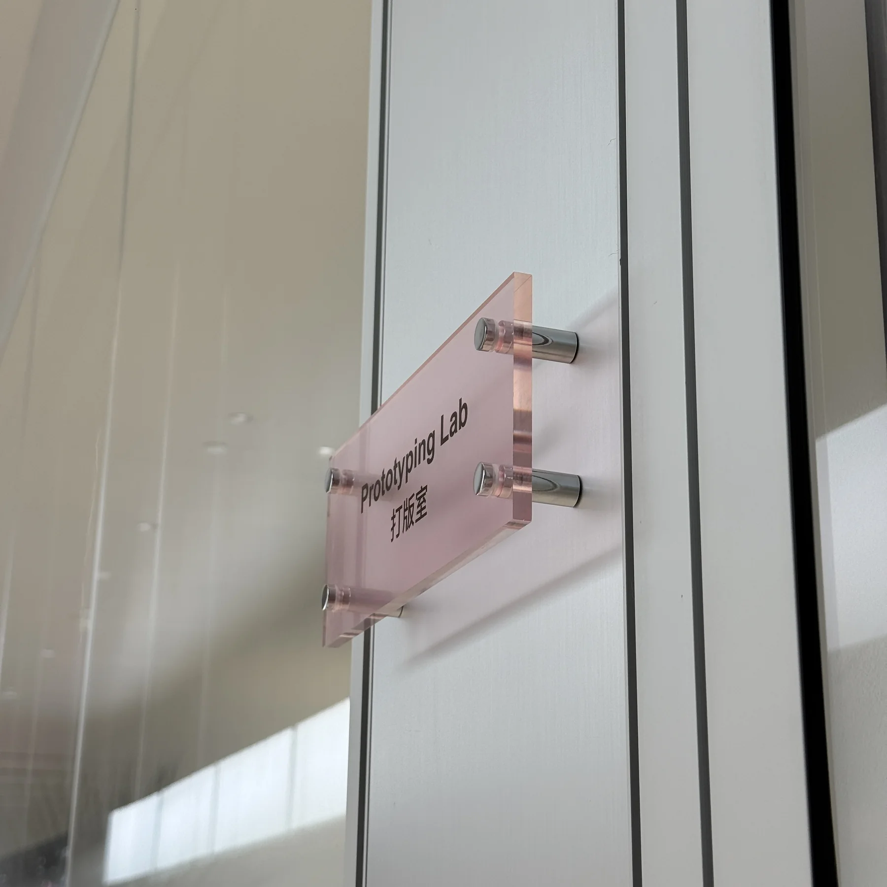 Acrylic wayfinding sign installed with architectural standoff hardware
