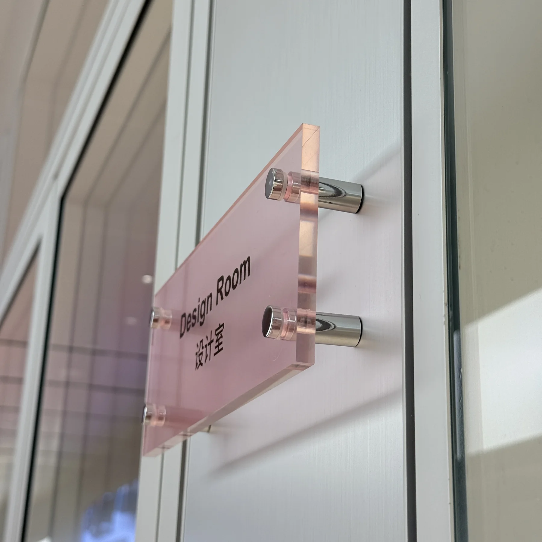 Clear acrylic sign panel installed with silver sign standoffs